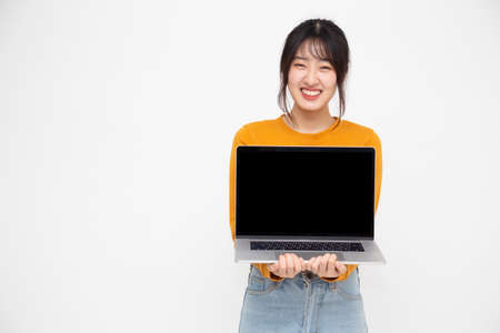 Young Asian woman showing a laptop computer over white background with copy space for presenting...