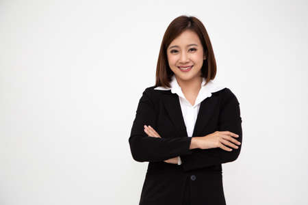 Portrait of successful business asian women in black suit with arms crossed and smile isolated over white background, Young businesswoman smiling and looking at camera, Happy feeling conceptの写真素材