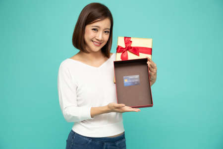 Asian woman holding and showing gold gift box and open the box with space to put products credit...