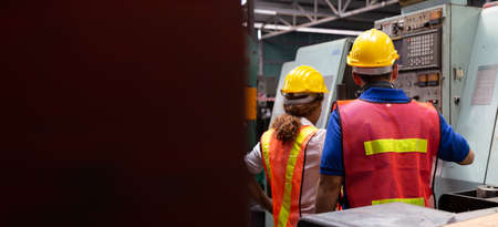 Head of factory engineer wearing yellow hard hat and checking the machine, Annual maintenance...