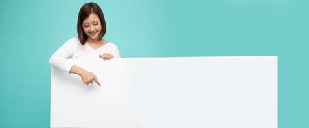 Young attractive asian woman showing and holding blank white board, Showing empty board for input your textの写真素材
