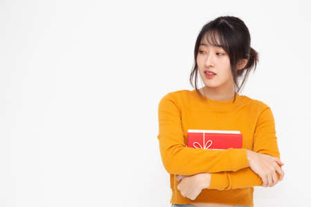 Happy beautiful asian woman smile with red gift box isolated on whiteの写真素材