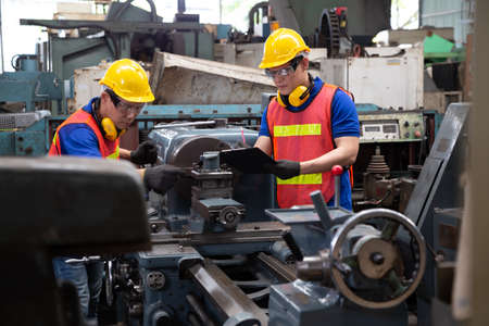 Asian factory engineer wearing yellow hard hat and checking the machine, Annual maintenance conceptの写真素材
