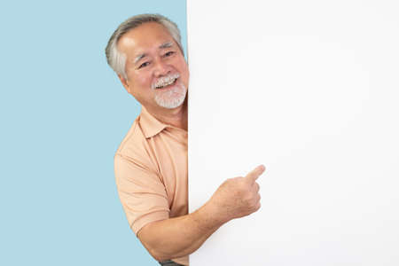 Smiling Asian senior man pointing towards something