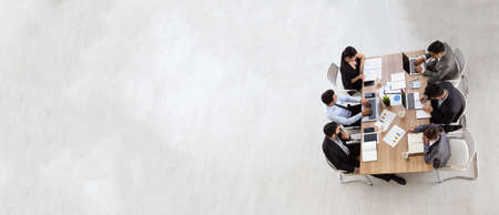 Top view of group of multiethnic busy people working in an office, Aerial view with businessman and businesswoman sitting around a conference table with blank copy space, Business meeting conceptの写真素材