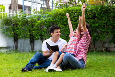 Happy family reading book in green garden together, Children learning education hobby concept
