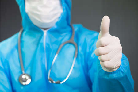 Doctor in Personal Protective Equipment or PPE suit uniform with gesture up confidence and thumbs up