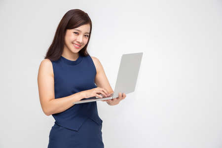 Young happy smiling Asian woman holding laptop isolated on white backgroundの写真素材