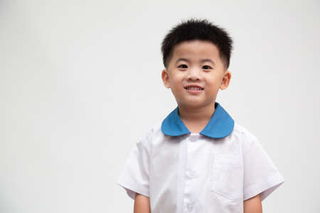 Cheerful smiling asian little boy in student uniform isolated on white background, First day of kindergarten and Back to School concept, Thai boy modelの写真素材