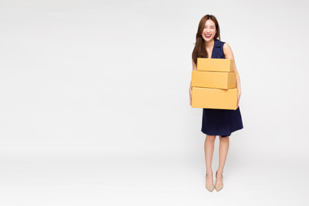 Happy Asian woman smiling and holding package parcel box isolated on white background, Delivery courier and shipping service conceptの写真素材