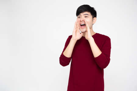 Portrait of excited screaming young asian man isolated over white background, Wow and surprised...