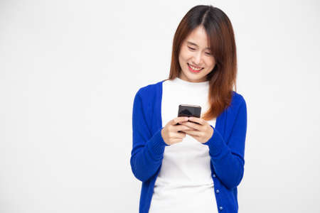 Cheerful young Asian woman using smartphone and receiving good news from the message on mobile chat...