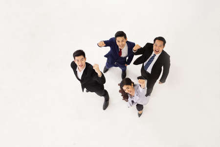 Top view of Asian business team celebrating a triumph with arms up isolated on white background, Successful entrepreneurs and business people conceptの写真素材