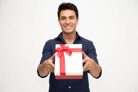 Portrait of a handsome young man giving gift box isolated on white background, Showing gift box conceptの写真素材