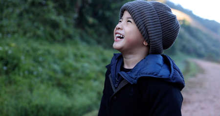 Asian boy wearing wool hat and laughing in winter season