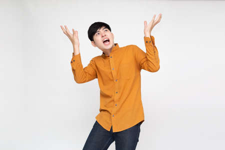 Young Asian man with open palms and mouth feeling shocked amazed isolated on white backgroundの写真素材