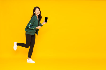 Asian fitness woman listening music with wireless earphone on telephone or smartphone isolated on...