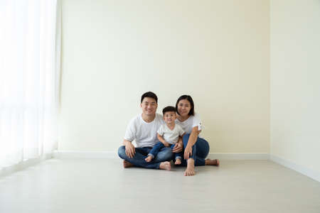 Asian family sitting on floor in the new room and new home, Relocation and real estate conceptの写真素材