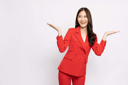 Happy Asian businesswoman presenting or showing open hand palm with copy space for product isolated over white backgroundの写真素材