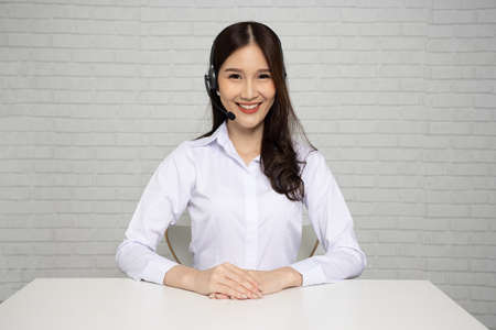 Asian call center and customer service looking at camera and wearing headset, Telemarketing, customer support agent provide service on telephone conceptの写真素材