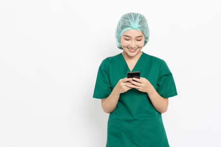 Asian nurse or doctor woman using mobile phone isolated over white backgroundの写真素材