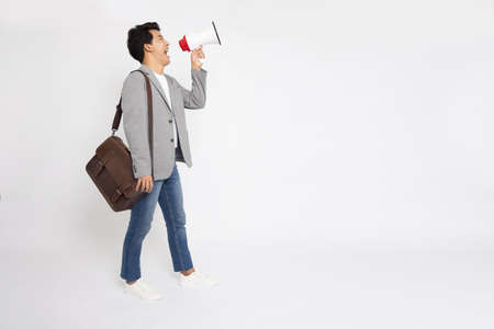 Young Asian business man holding megaphone isolated on white background, Speaker and announce concept, Full body compositionの写真素材