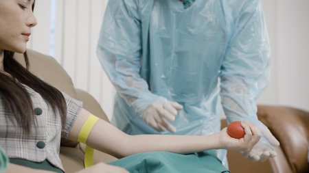 Male doctor is teaching a blood donors to squeeze her hand, Donate blood and volunteering conceptの写真素材