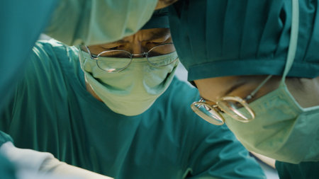 Asian doctor uses a scalpel to the patient with surgical team in operating roomの写真素材