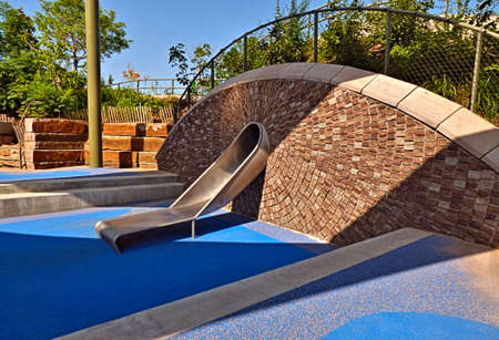 Metal slide through a tunnel with an eliptical rock background at The Gathering Place in Tulsa...
