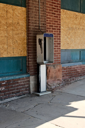 Old phone booth in front of a brick wall in the street. Located on Route 66 in Depew, Oklahoma.の写真素材