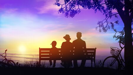 A couple and a child during a bike ride resting under the tree facing the oceanの写真素材