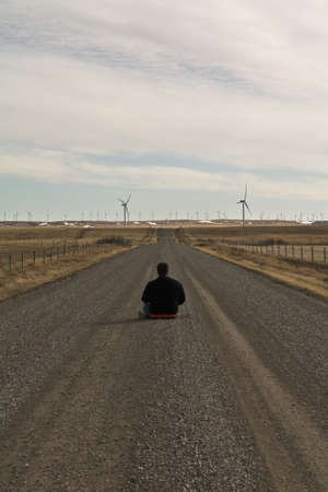 lonely man watching wind mills on the horizonの写真素材