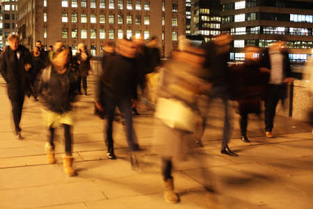 Commuters at night on London Bridge, London, England.の写真素材