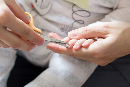 Mother cut off her baby s fingernails of the handの写真素材