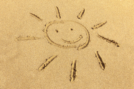 Smiling sun - hand drawing in the sandの写真素材