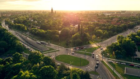High traffic intersection and city skyline seen by a professional drone at sunsetの写真素材