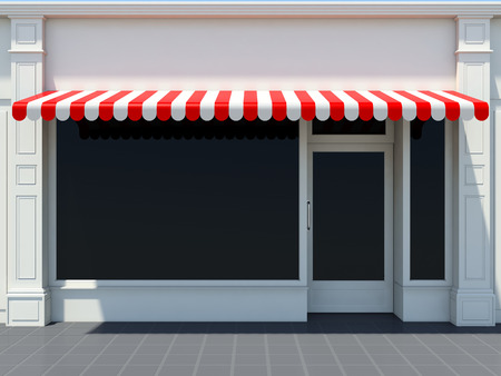 White shopfront in the sun - classic store front with red awningsの写真素材