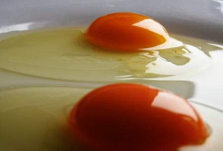 Two raw eggs on a plateの写真素材