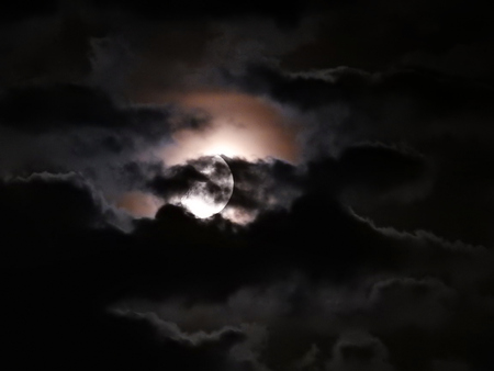 Moon in phase between black clouds