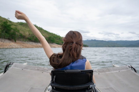 Woman female person happy fun travel on boat activity in summer lake vacation, beautiful outdoor lifestyle nature adventure smiling sea trip recreation, relax landscape activity sitting canoe joy skyの写真素材