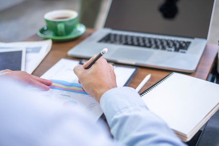 Closeup professional businessman hand pen writing work document strategy on tablet technology indoor workplace office table, adult entrepreneur business man manager person note finance report notepadの写真素材