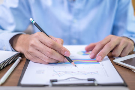 Closeup professional businessman hand pen writing work document strategy on tablet technology indoor workplace office table, adult entrepreneur business man manager person note finance report notepadの写真素材