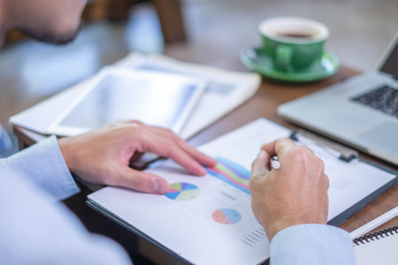 Closeup professional businessman hand pen writing work document strategy on tablet technology indoor workplace office table, adult entrepreneur business man manager person note finance report notepadの写真素材