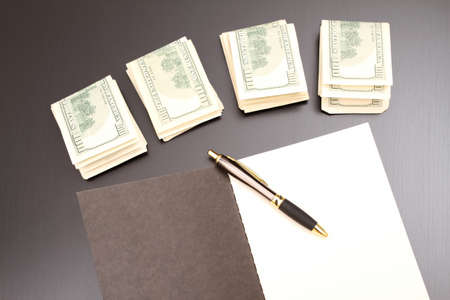 Lots of dollars with an open copybook