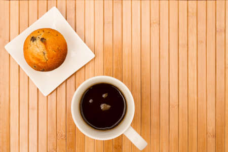 Vanilla with chocolate chips Muffins on a white plate with  a cup of coffeeの写真素材