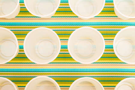 Lots of disposable cups on a colorful backgroundの写真素材