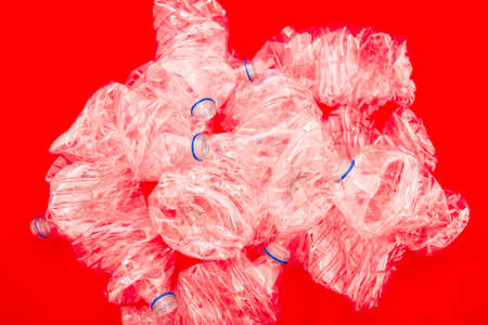 Squeezed bottles of mineral water with a red background