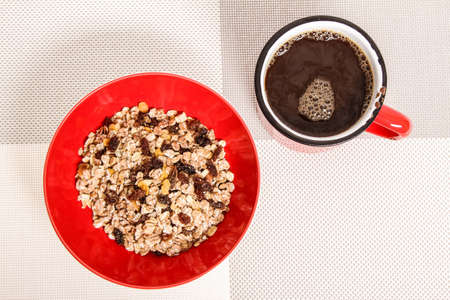 A cup of coffee and a bowl with mixed fruit Muesliの写真素材