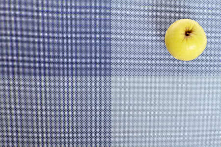 Green apple on a blue placemat
