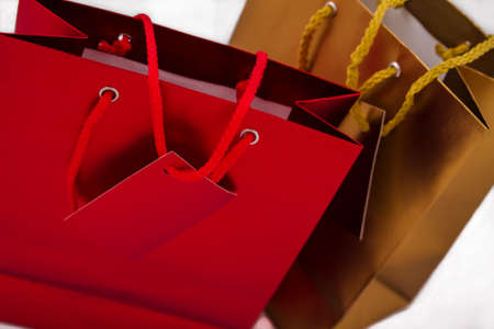 Two gift bags, one red and one gold, isolatedの写真素材